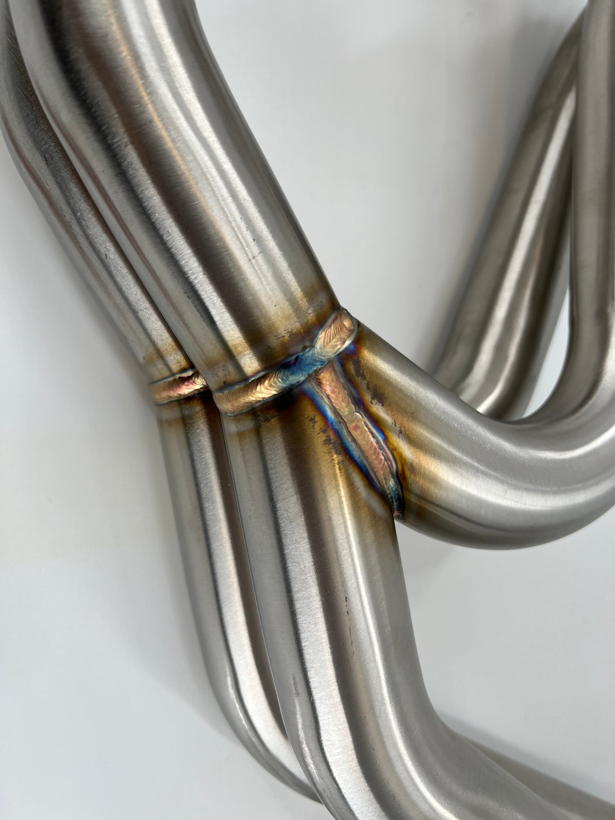 Subaru WRX and STi EJ25 equal length exhaust manifold header by JackSpania Racing, showing polished metal construction and flange details.