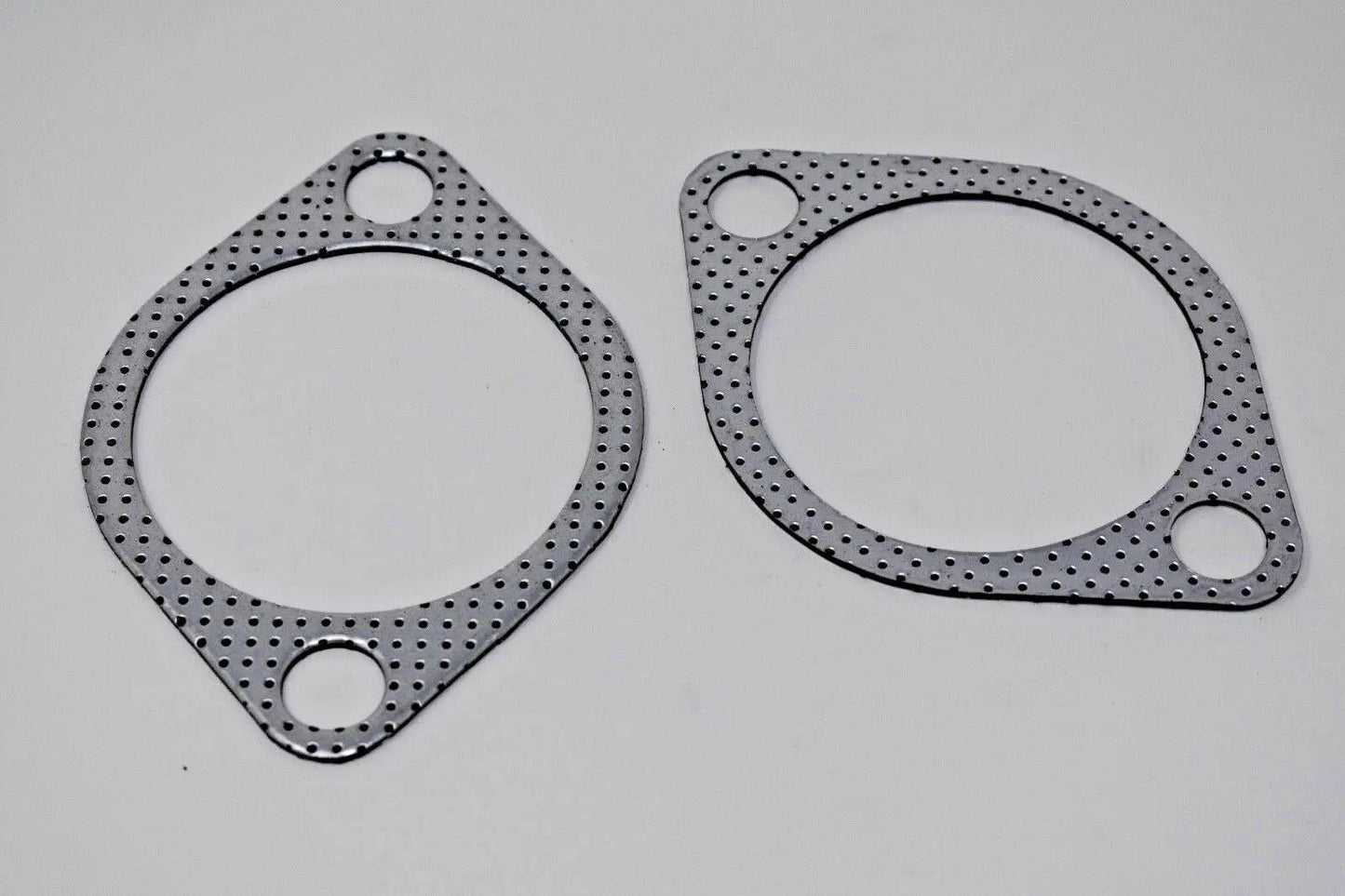 Two 2.5-inch downpipe-to-exhaust gaskets for Subaru WRX STI EVO X 10 GT, made by Jack Spania Racing, with bolt holes for engine installation.