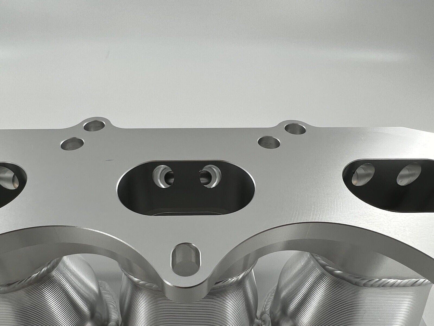 Jack Spania Racing Billet B Series Intake Manifold Adapter Kit for Skunk2 Ultra Plenum engine parts, showing the metal components.