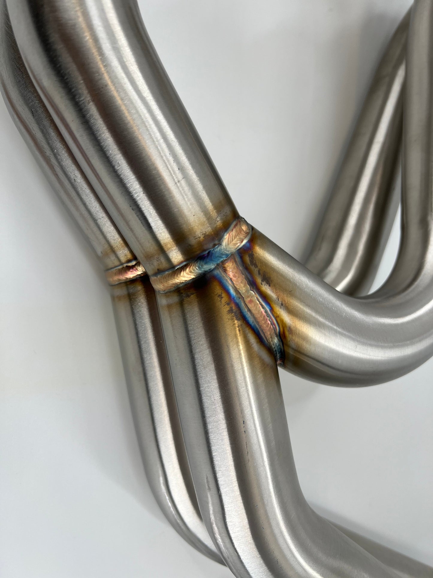 Subaru WRX and STi EJ25 equal length exhaust manifold header by JackSpania Racing, showing polished metal construction and flange details.