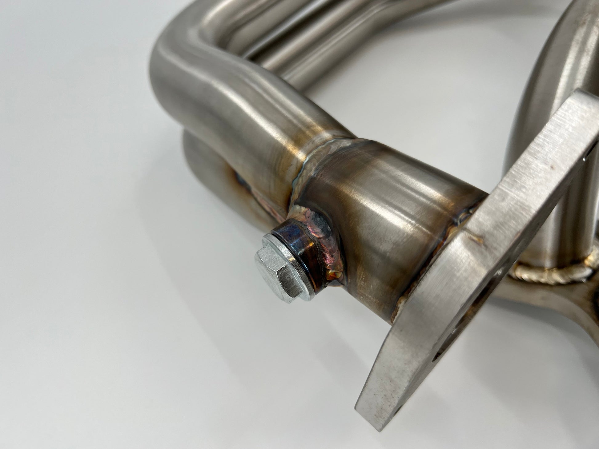 Subaru WRX and STi EJ25 equal length exhaust manifold header by JackSpania Racing, showcasing the polished metal construction and flange.