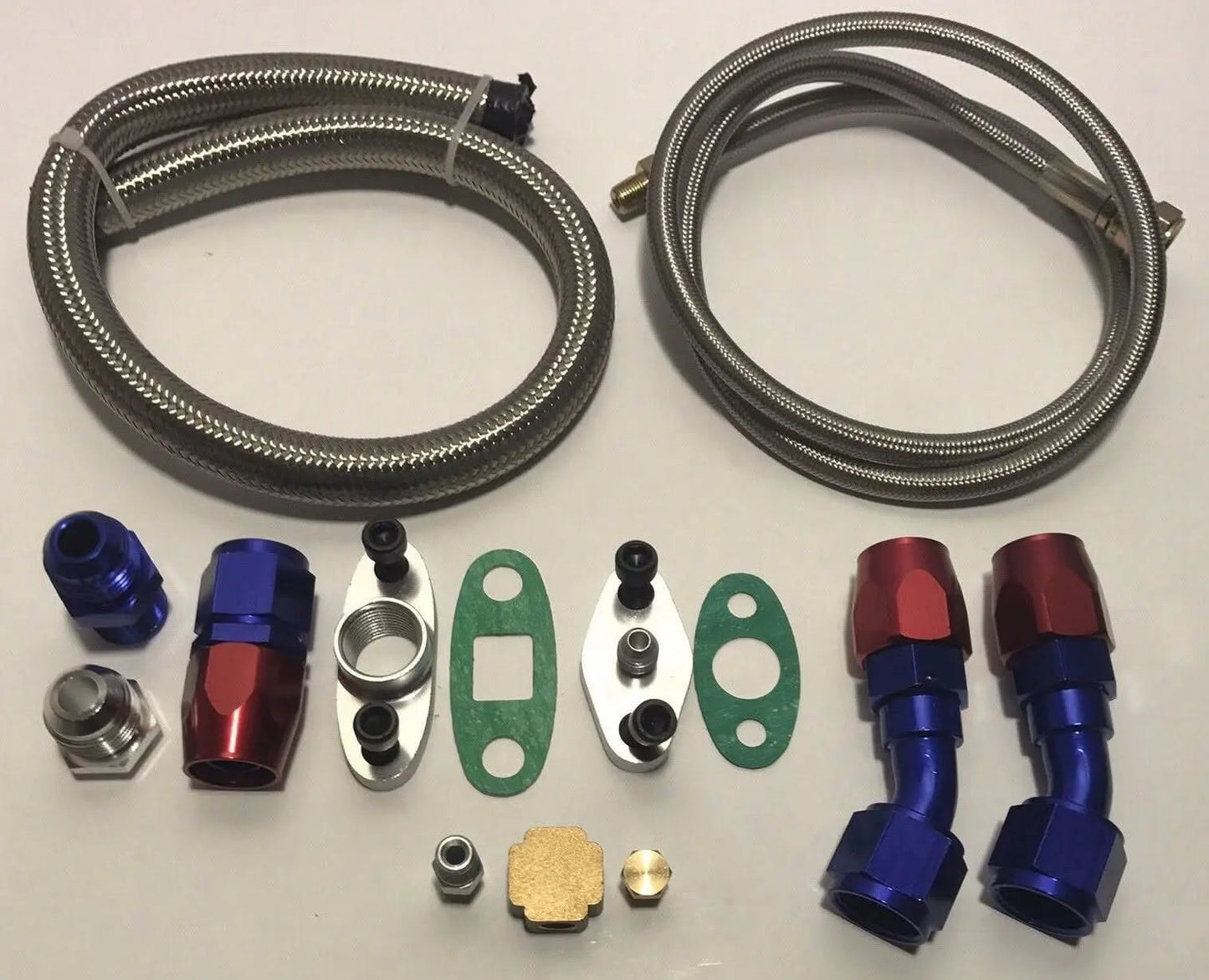 Stainless Turbo Oil Drain Return and Feed Line kit for T3 T4 T60 T61 T70 turbos, by Jack Spania Racing, showing polished engine parts.