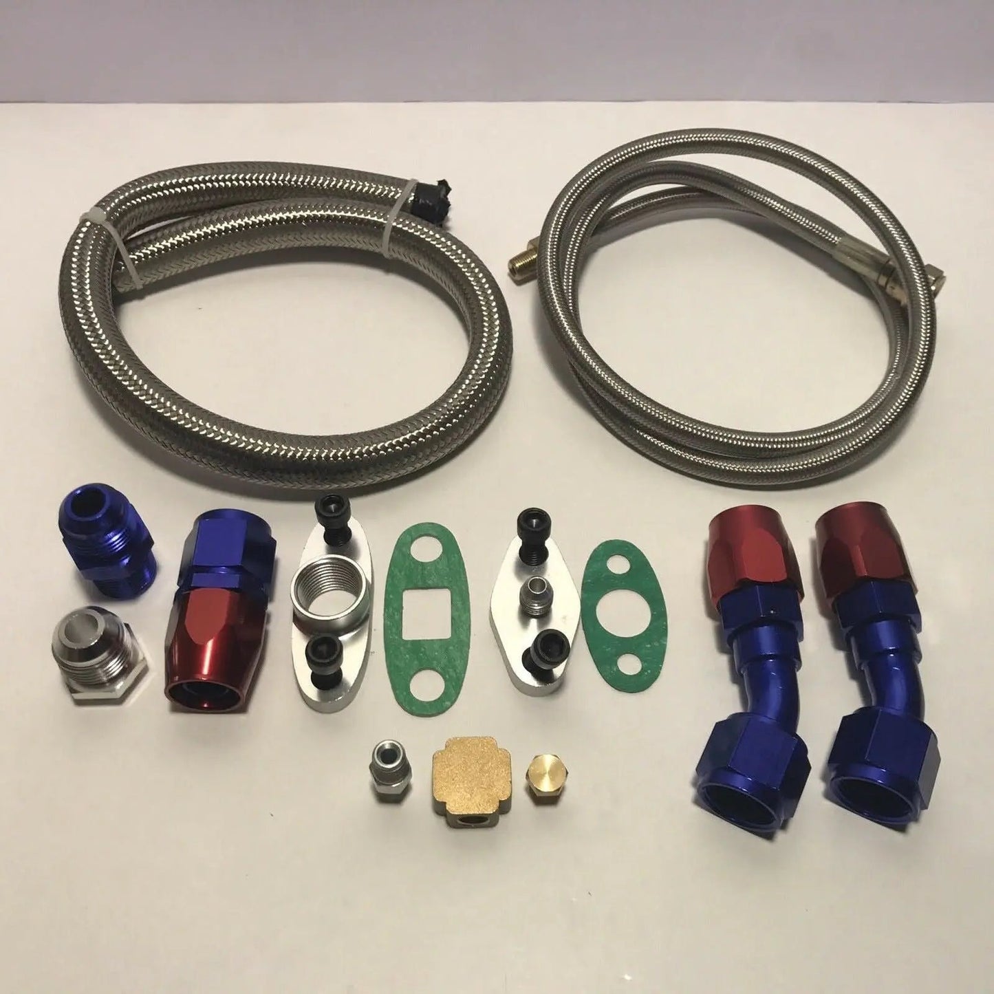 Jack Spania Racing stainless turbo oil drain return and feed line kit with T3 T4 T04E T60 T61 T70 engine parts shown.
