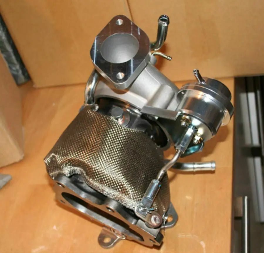 Jack Spania Racing thermal turbo blanket heat shield installed on a Subaru WRX and STi engine, protecting engine components.