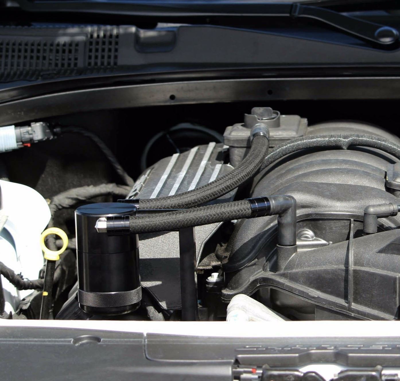Jack Spania Racing catch can for Chrysler 300 Hemi, Charger, Challenger 5.7L-6.4L engine parts, image shows the black aluminum catch can.