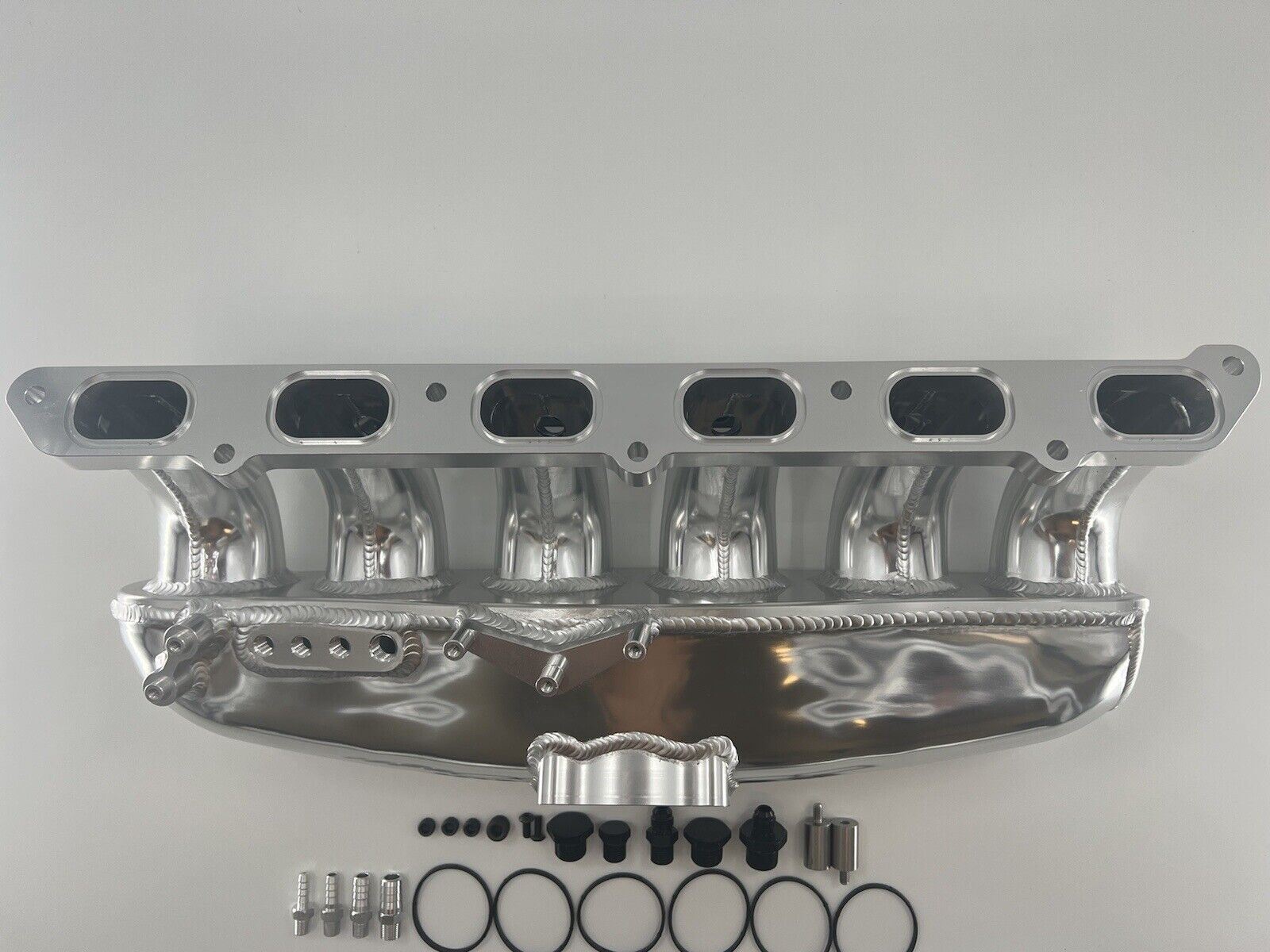 Center feed intake manifold fuel rail for BMW N54 135i, 335i, and 535i E90 engine, by Jack Spania Racing, showing the metal component with fittings.