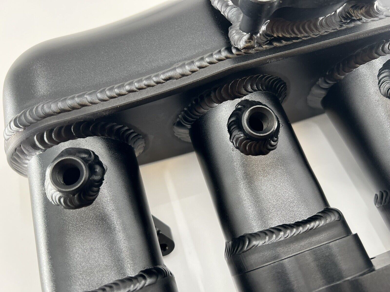 Engine intake manifold for VW Audi EA888 Gen 3 1.8T 2.0T by Jack Spania Racing, showing the metal construction and connection points.