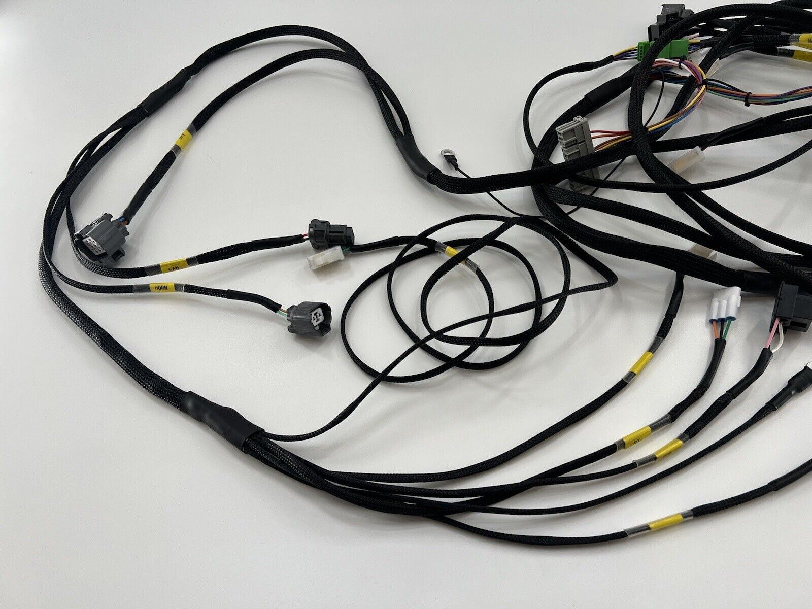 Honda Acura EG 92-95 front headlight wire tuck harness by Jack Spania Racing, shown with engine parts and blinker components.