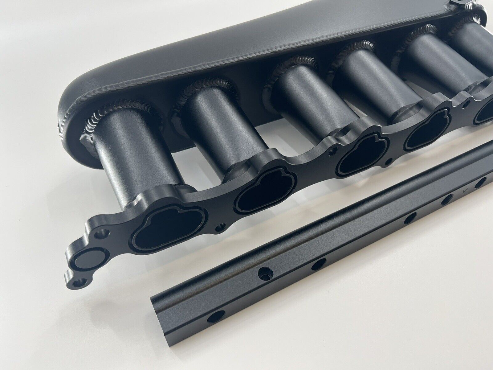 Jack Spania Racing 1JZ GTE billet intake manifold with fuel rail and 90mm throttle body for engine performance enhancement.