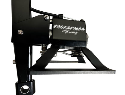 Self-centering short shifter box for BMW E30 to F87 models by Jack Spania Racing, showing the compact transmission part in a workshop setting.