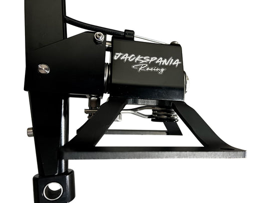Self-centering short shifter box for BMW E30 to F87 models by Jack Spania Racing, showing the compact transmission part in a workshop setting.