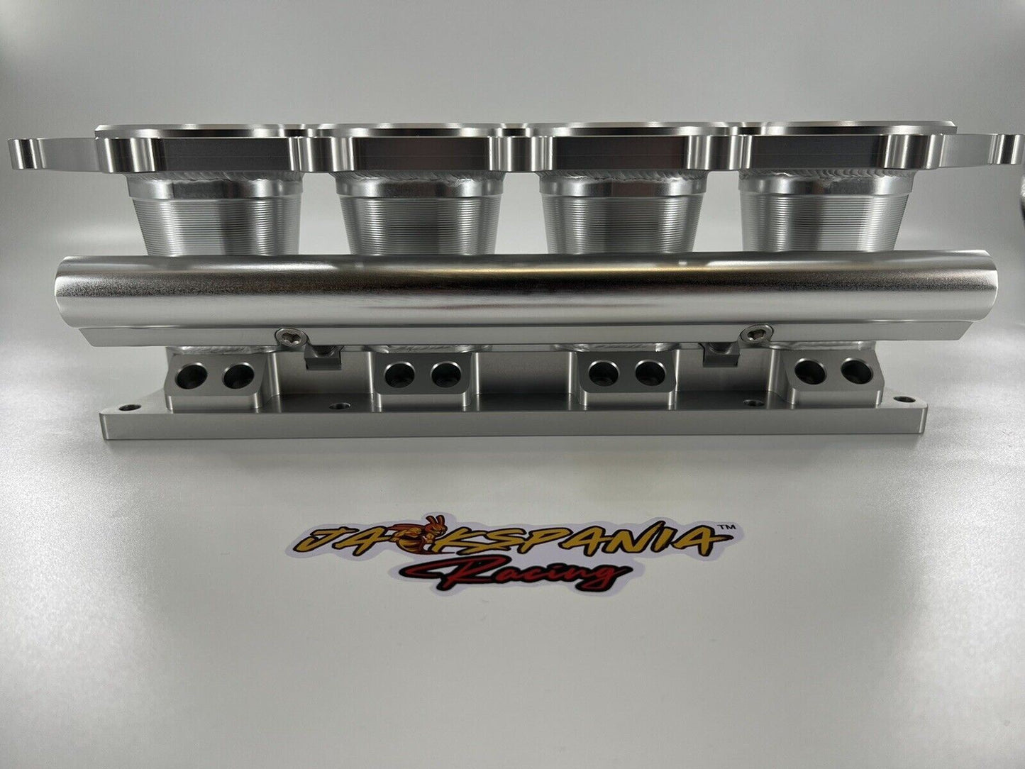 Jack Spania Racing billet K Series intake manifold adapter for Skunk2 Ultra engine parts, showing the precision-machined metal component.