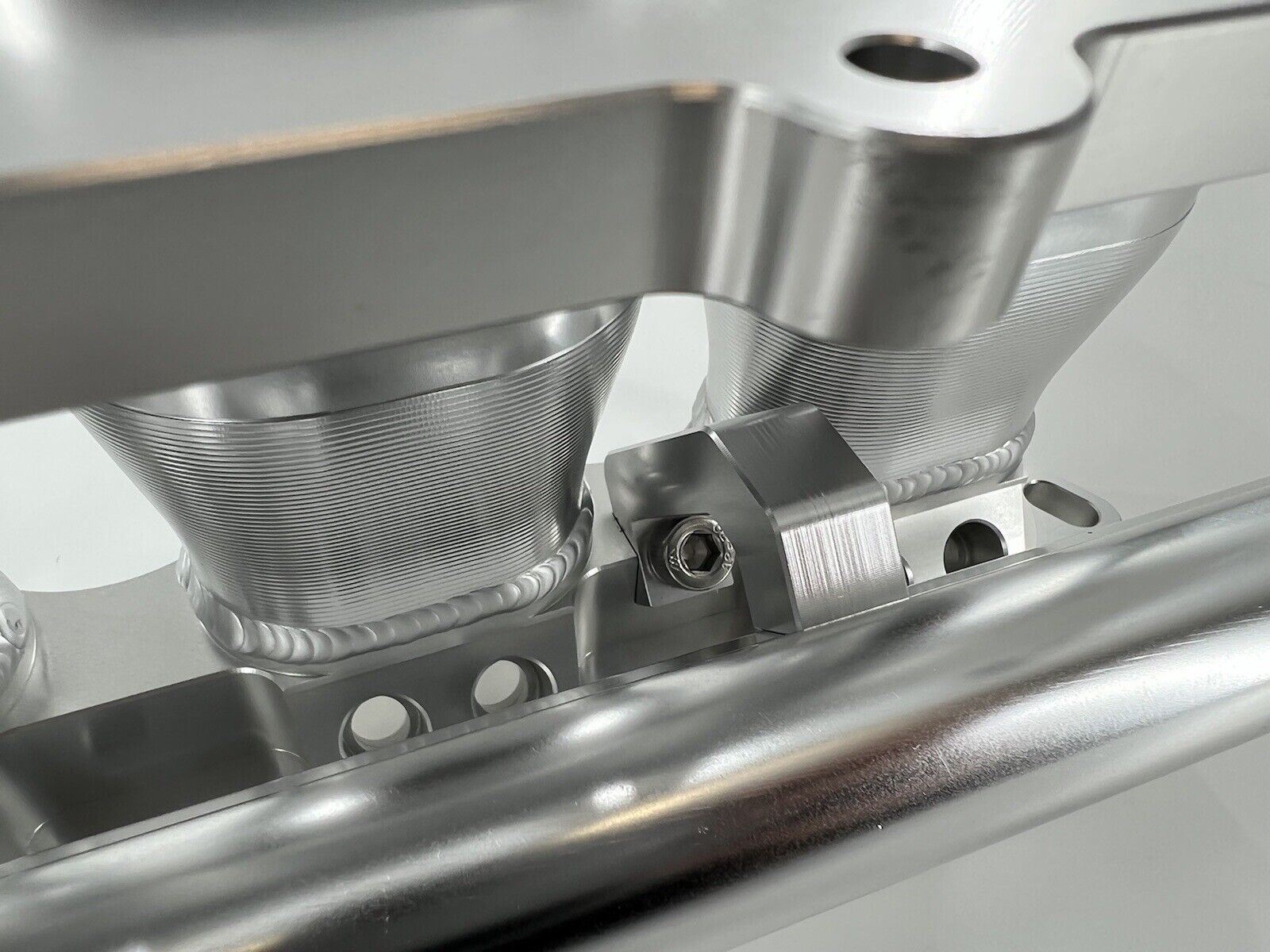 Jack Spania Racing billet K series intake manifold adapter for Skunk2 Ultra engine parts, displayed on a clean surface.