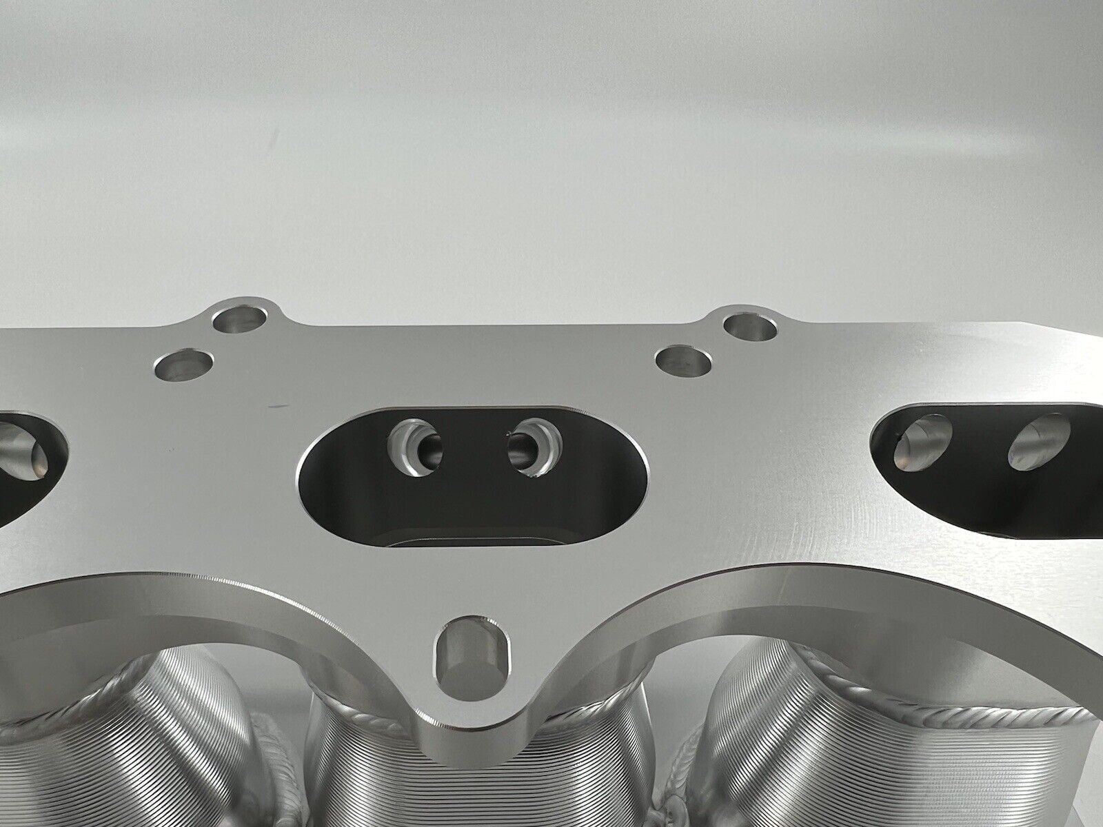 Jack Spania Racing Billet B Series Intake Manifold Adapter Kit for Skunk2 Ultra Plenum engine parts, showing the metal components.