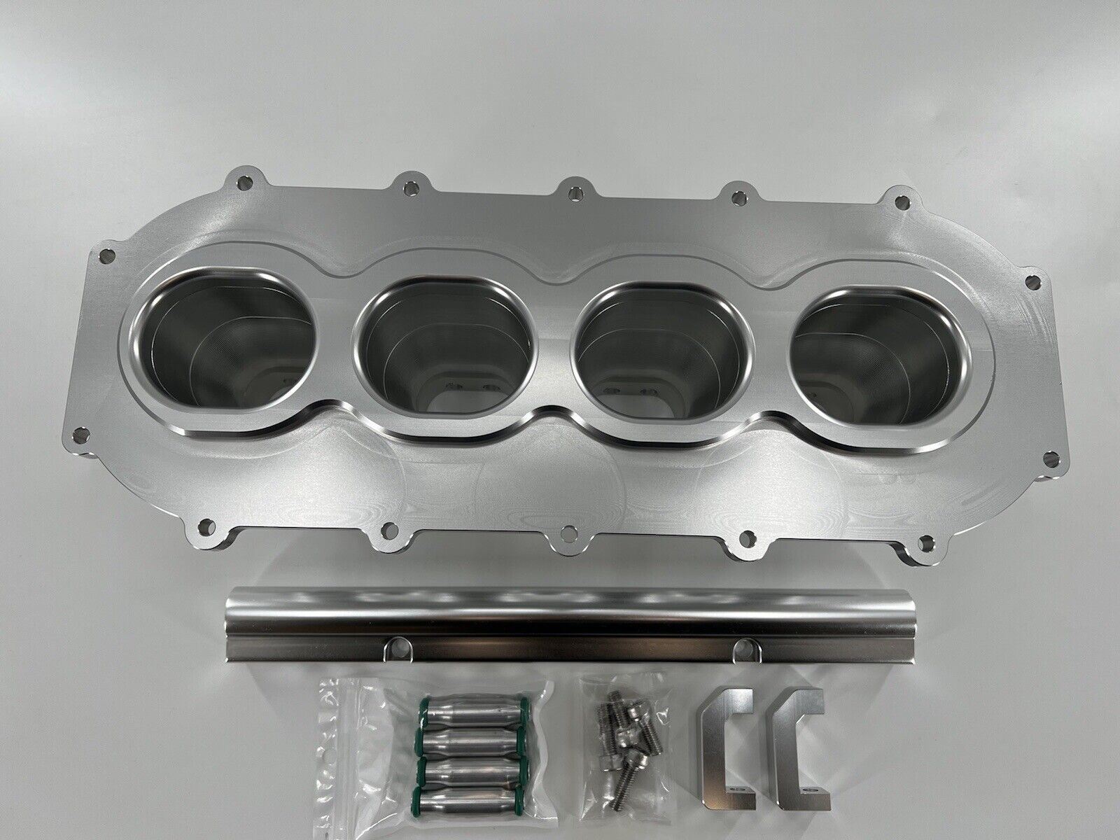 Jack Spania Racing billet B Series intake manifold adapter kit for Skunk2 Ultra Plenum engine upgrade, showing the precision-machined metal parts.
