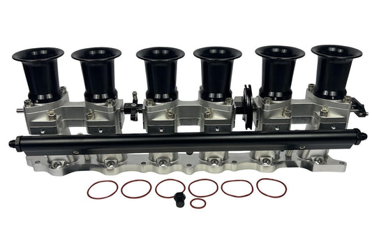 JackSpania Racing intake manifold with individual throttle bodies, fuel rail, and engine parts for 2JZGE engine.
