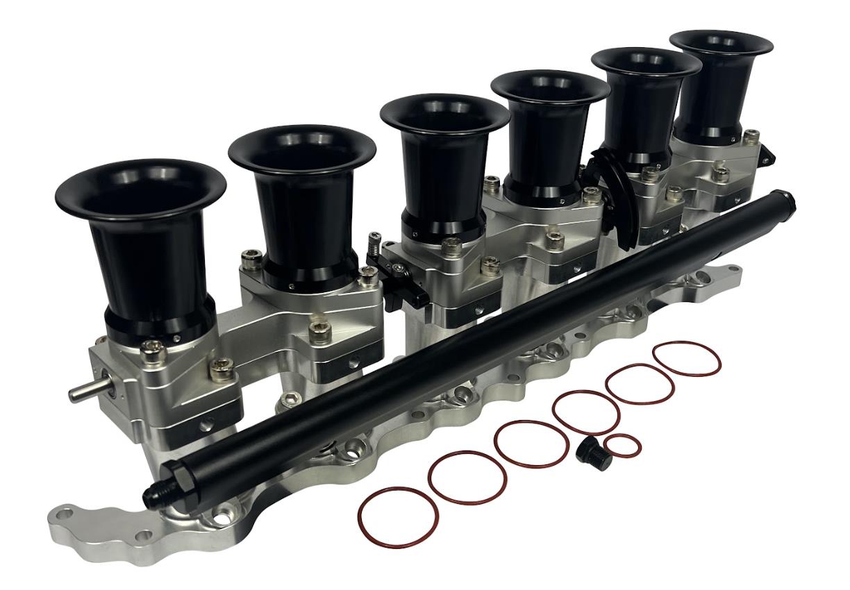 JackSpania Racing intake manifold with individual throttle bodies, fuel rail, and engine parts for 2JZGE Toyota engine.