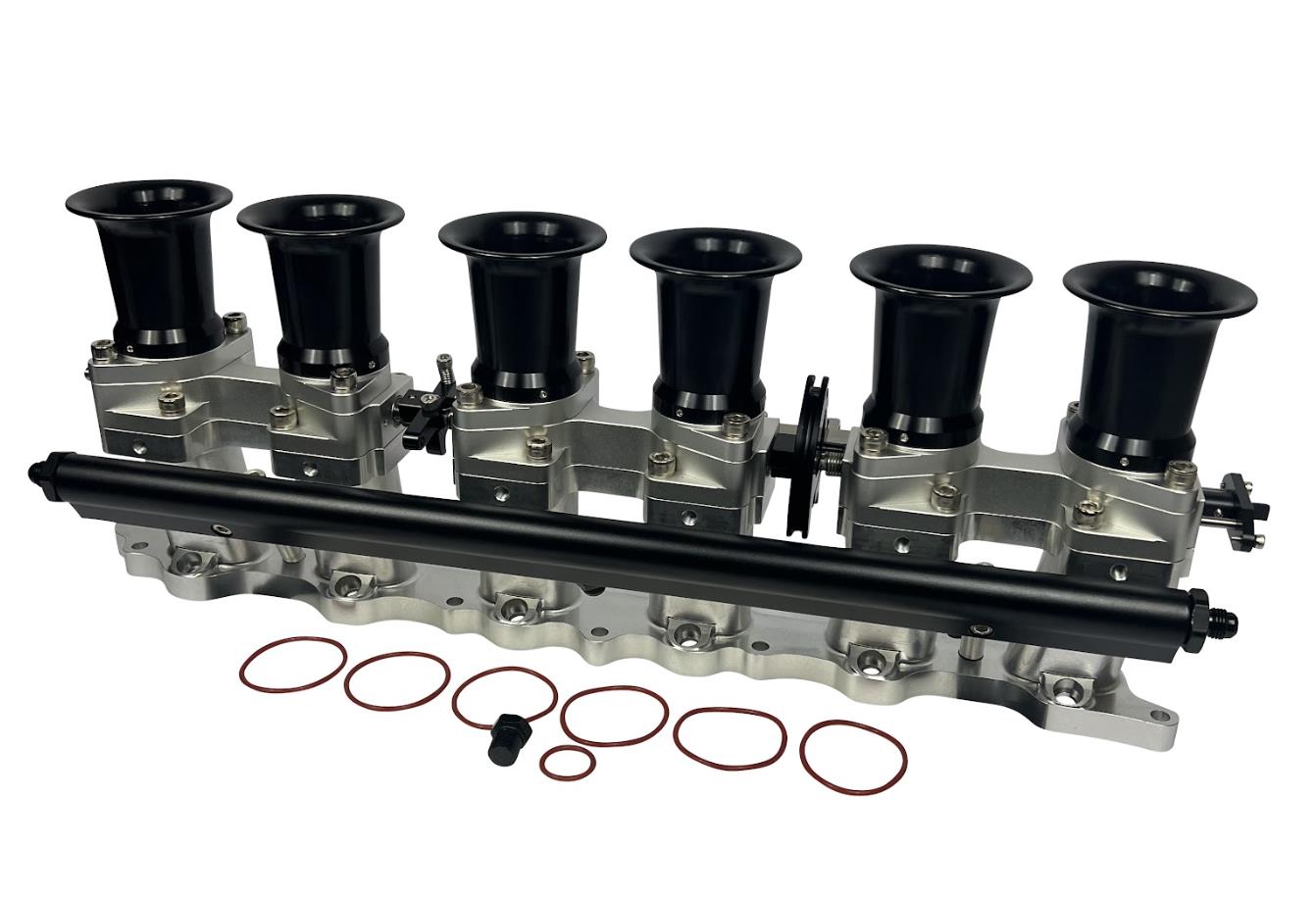 JackSpania Racing 2JZGE intake manifold with individual throttle bodies, fuel rail, and engine components for performance tuning.