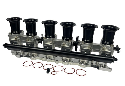 JackSpania Racing 2JZGE intake manifold with individual throttle bodies, fuel rail, and engine components for performance tuning.