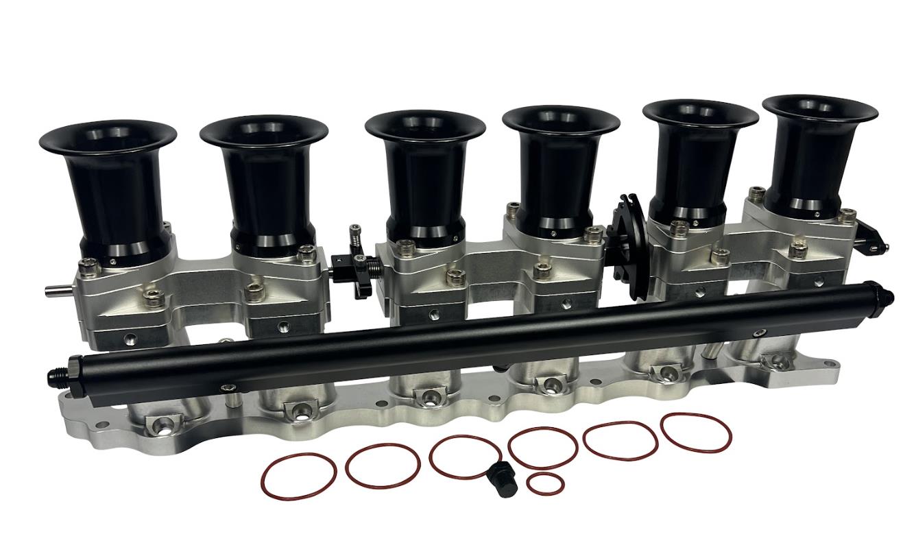 JackSpania Racing intake manifold with individual throttle bodies and fuel rail for 2JZGE engine, showing metal components and fittings.