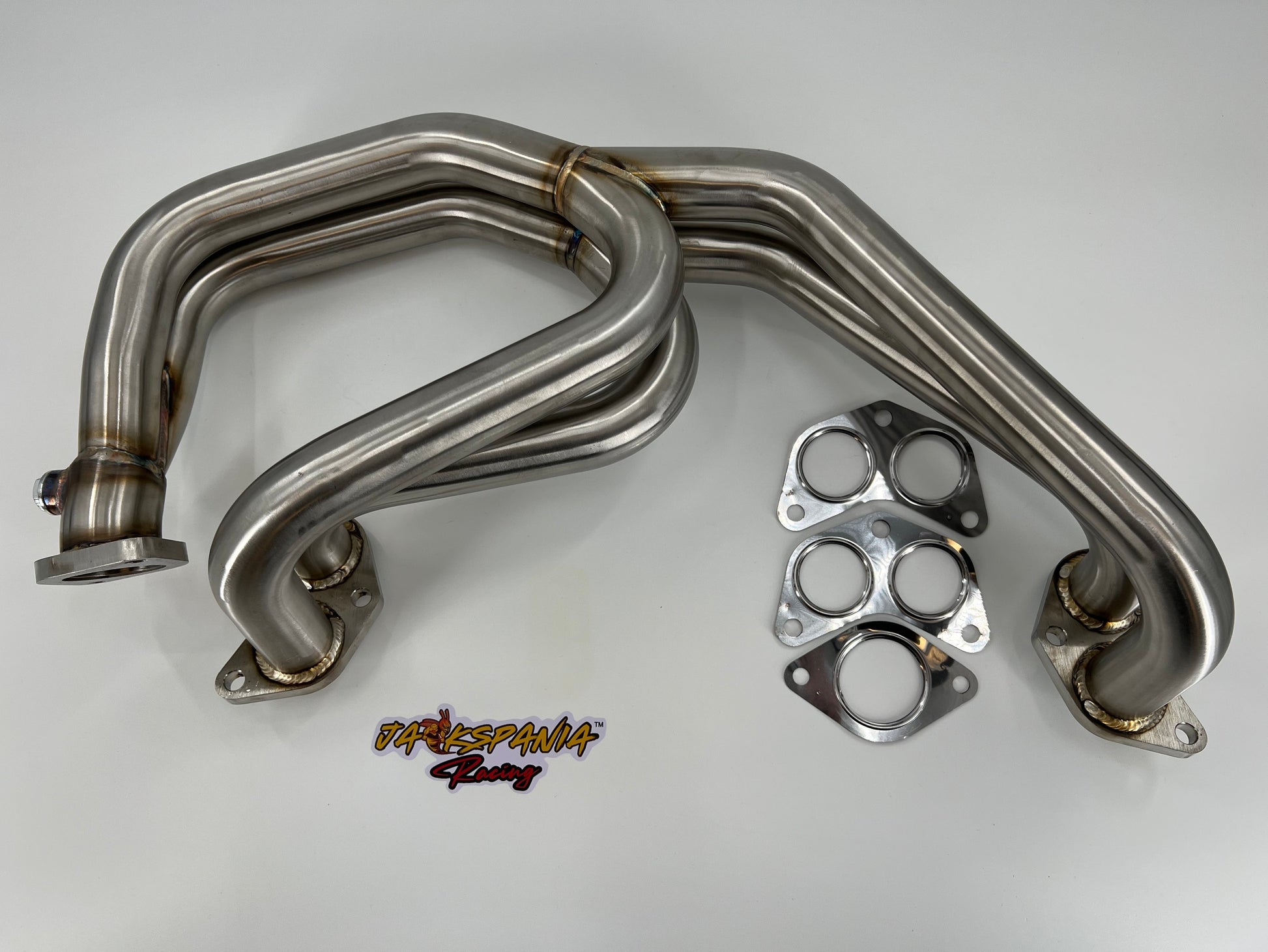 Subaru WRX and STi EJ25 equal length exhaust manifold header by JackSpania Racing, showcasing polished metal construction and inlet ports.