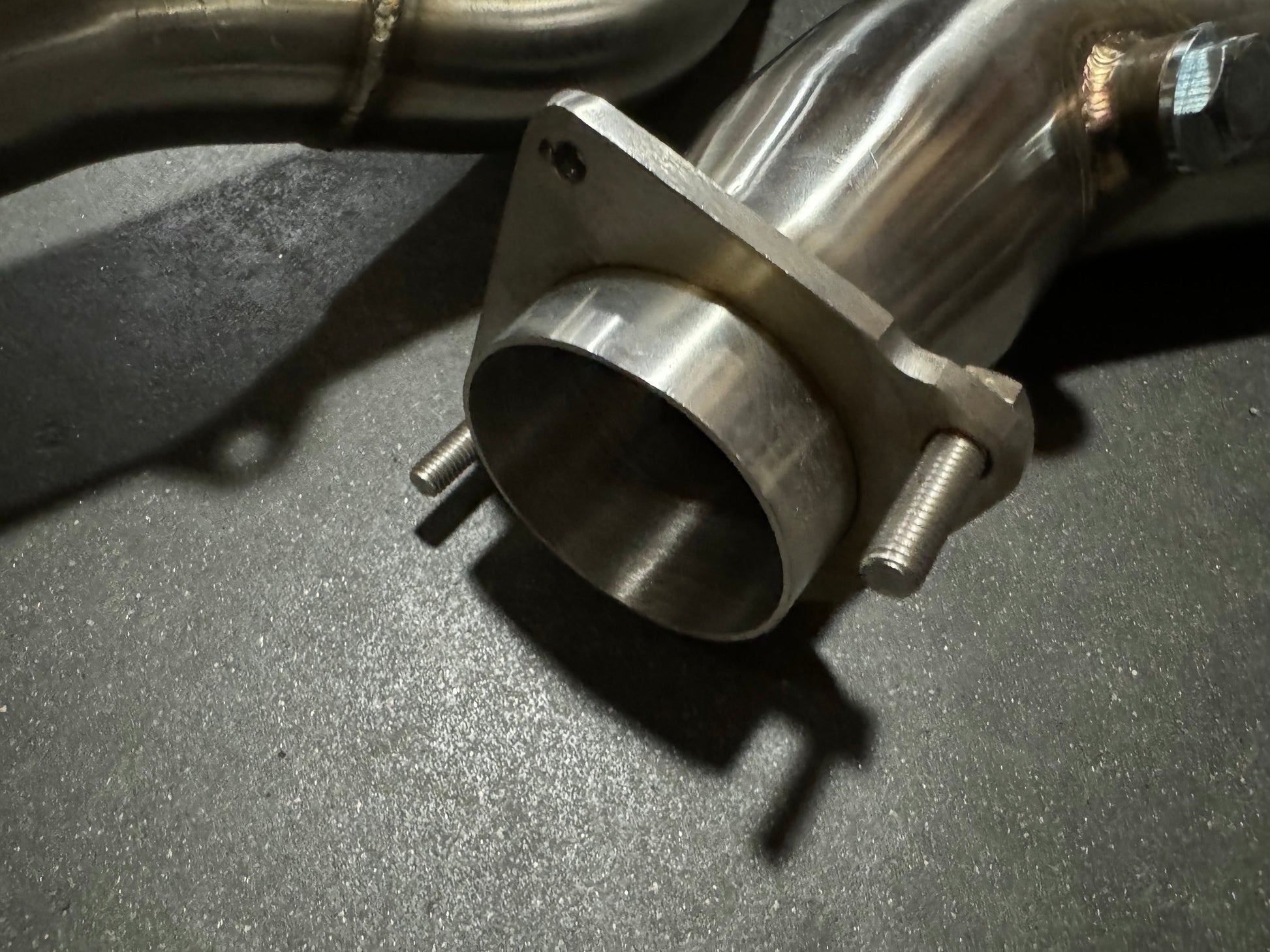 Stainless steel 3-inch downpipe for BMW S55 F80 F82 F87 M3 M4 F83 by JackSpania Racing, showing the exhaust component's polished finish.