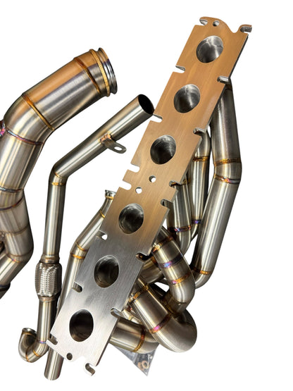 BMW S58 G80 G82 G83 G87 single turbo manifold hot-side kit by JackSpania Racing, showing polished metal components and mounting points.