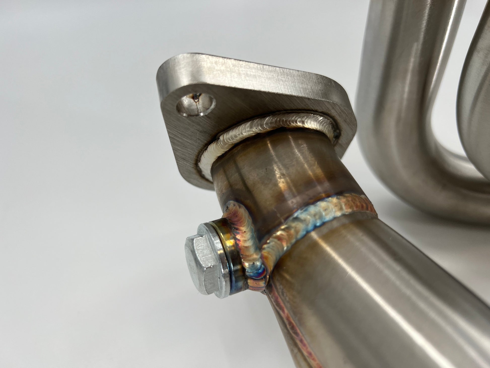 Subaru WRX & STi EJ25 equal length exhaust manifold header by JackSpania Racing, showing polished metal pipes and flange details.