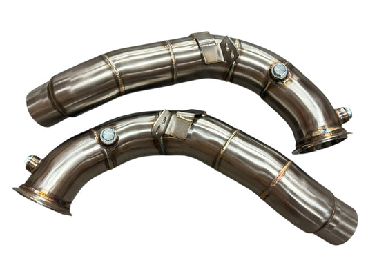 JackSpania Racing racing downpipes for BMW M5 and M6 S63 2011-2018, showing polished stainless steel exhaust pipes with mounting brackets.