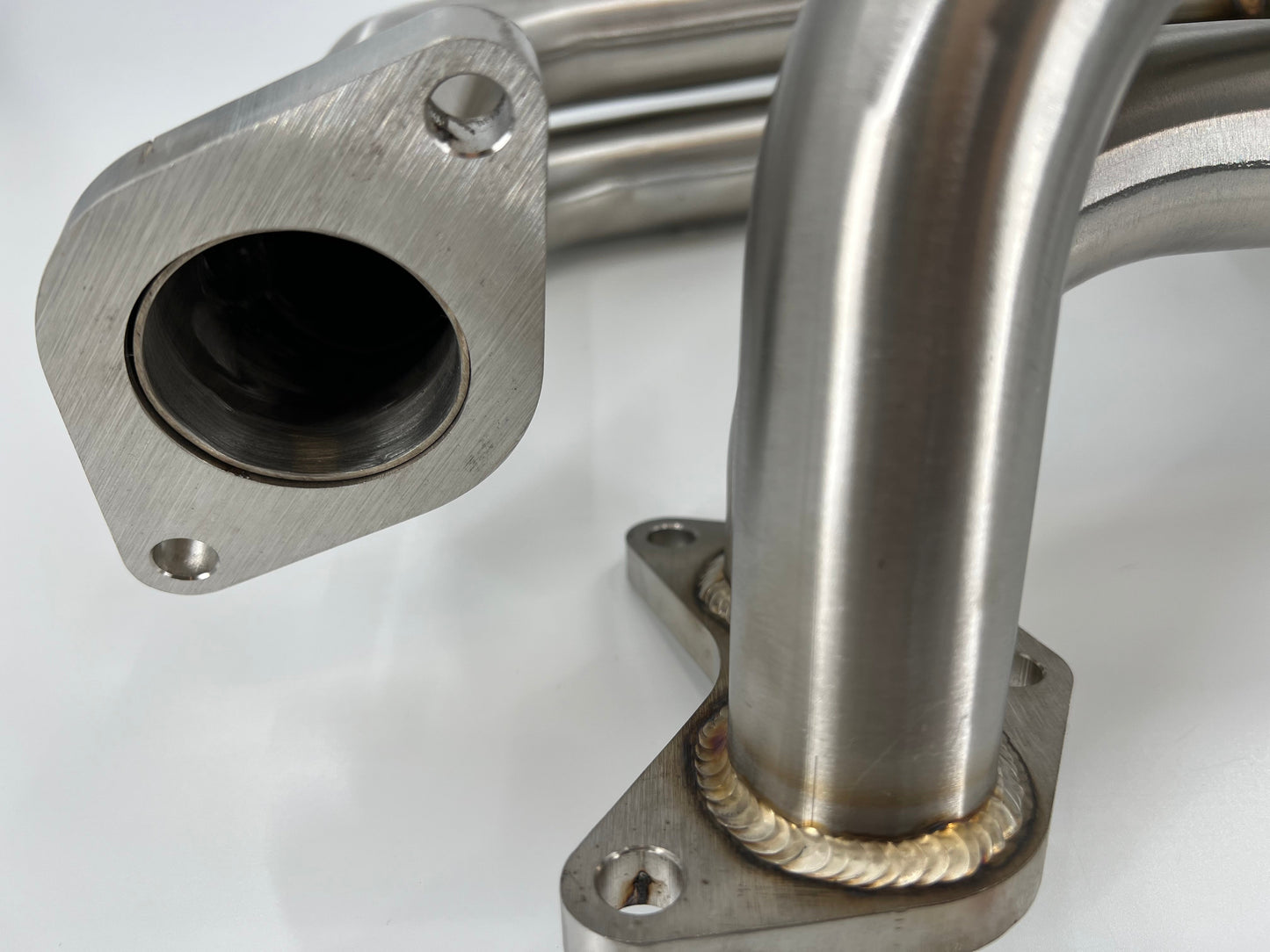 JackSpania Racing Subaru WRX STI EJ25 equal length exhaust manifold header showing polished metal pipes and mounting flanges.