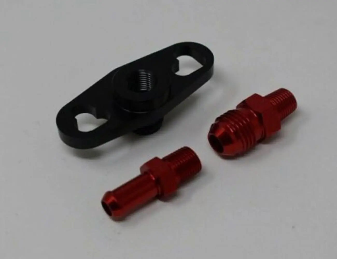 Fuel pressure regulator FPR adapter for Nissan, Subaru, Toyota engines, 1/8NPT, by Jack Spania Racing, shown on engine part.